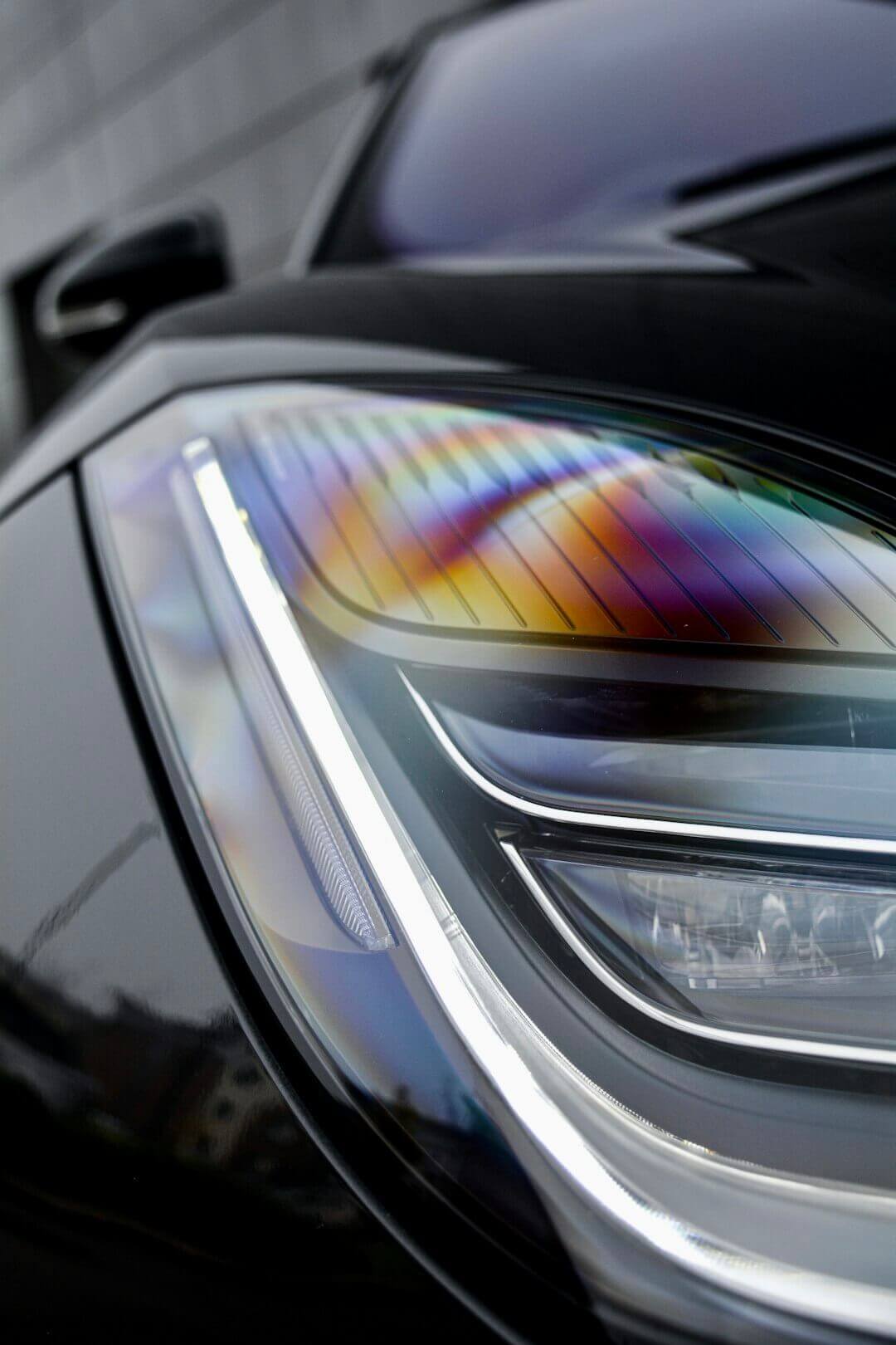 Close-up of a car headlight showcasing vibrant graphic design elements, reflecting the influence of design on car culture.
