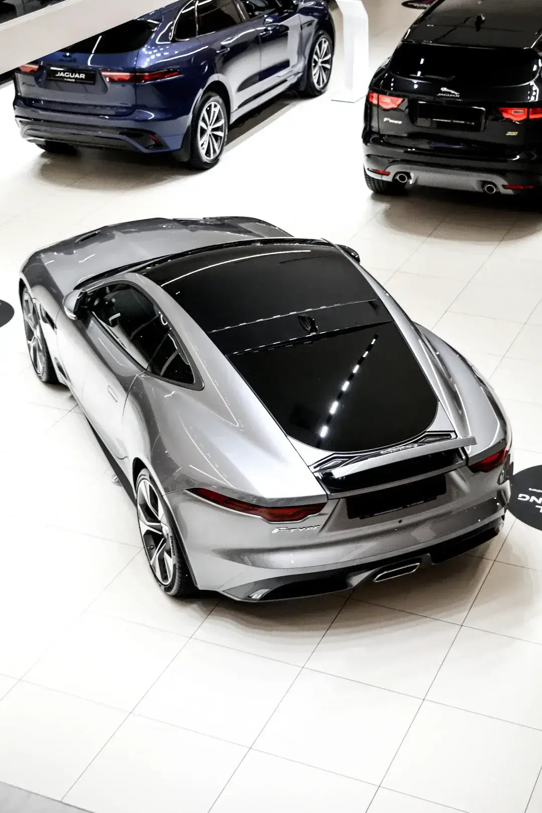 Sleek silver sports car in showroom embodies cultural influences on automotive aesthetics.
