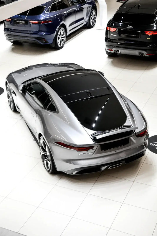 Sleek silver sports car in showroom embodies cultural influences on automotive aesthetics.