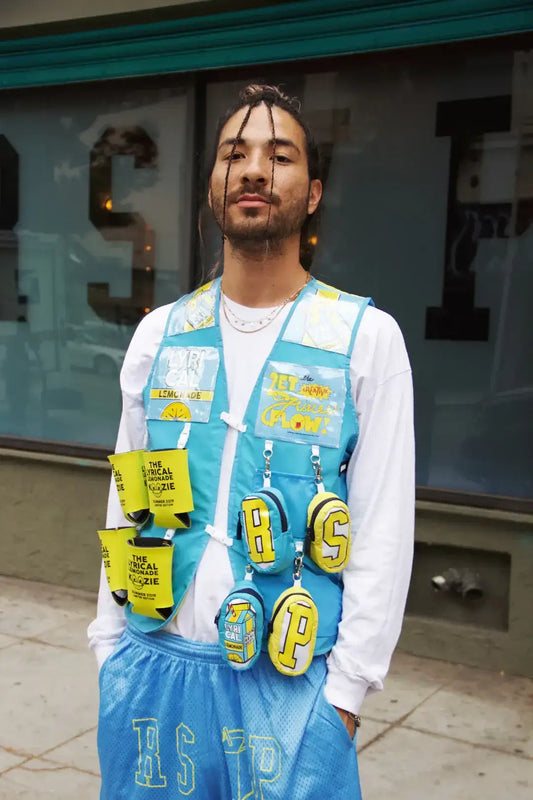 Fashionable man wearing eco-friendly outfit with blue vest and recycled material accessories.