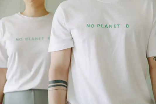 "Close-up of people wearing white shirts with 'No Planet B' design on the front, highlighting popular front design placement trend"