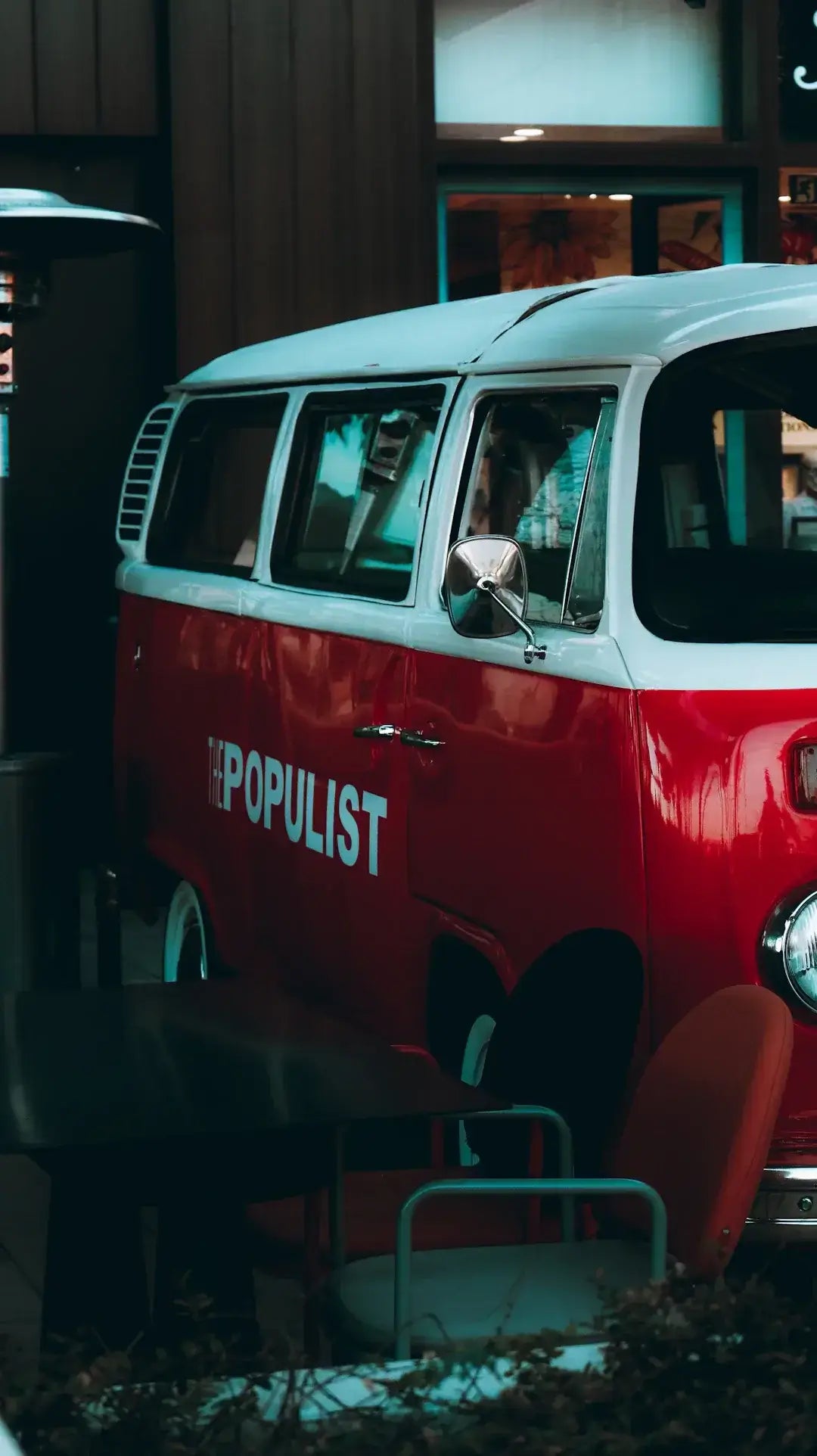 Retro van with street art-inspired design parked outside a cafe, showcasing urban creativity in automotive aesthetics.