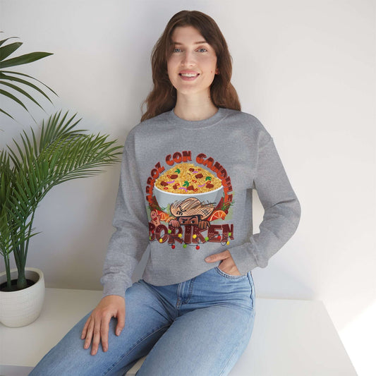 Woman wearing Arroz Con Gandules Christmas sweater with festive rice and peas graphic and "BORIKÉN" text, sitting by a plant.